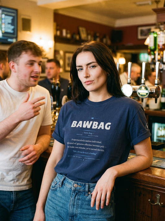 Woman in a pub wearing the navy BAWBAG dictionary definition tee